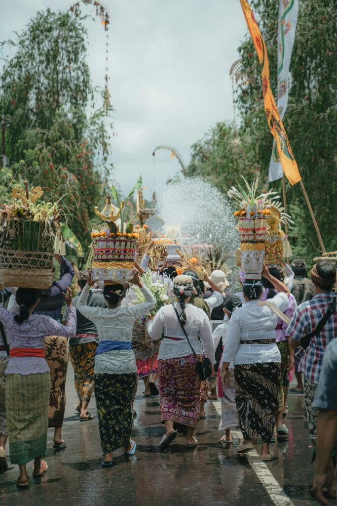 Balinese women in traditional attire carrying offerings to the temple, reflecting the spiritual and communal values of Indonesian culture