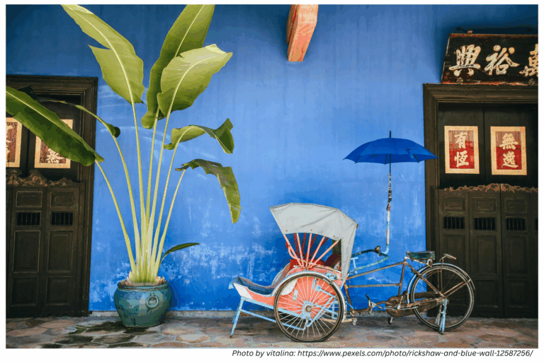 Vintage rickshaw in front of blue heritage wall in George Town, Penang – part of a Penang visa run travel story