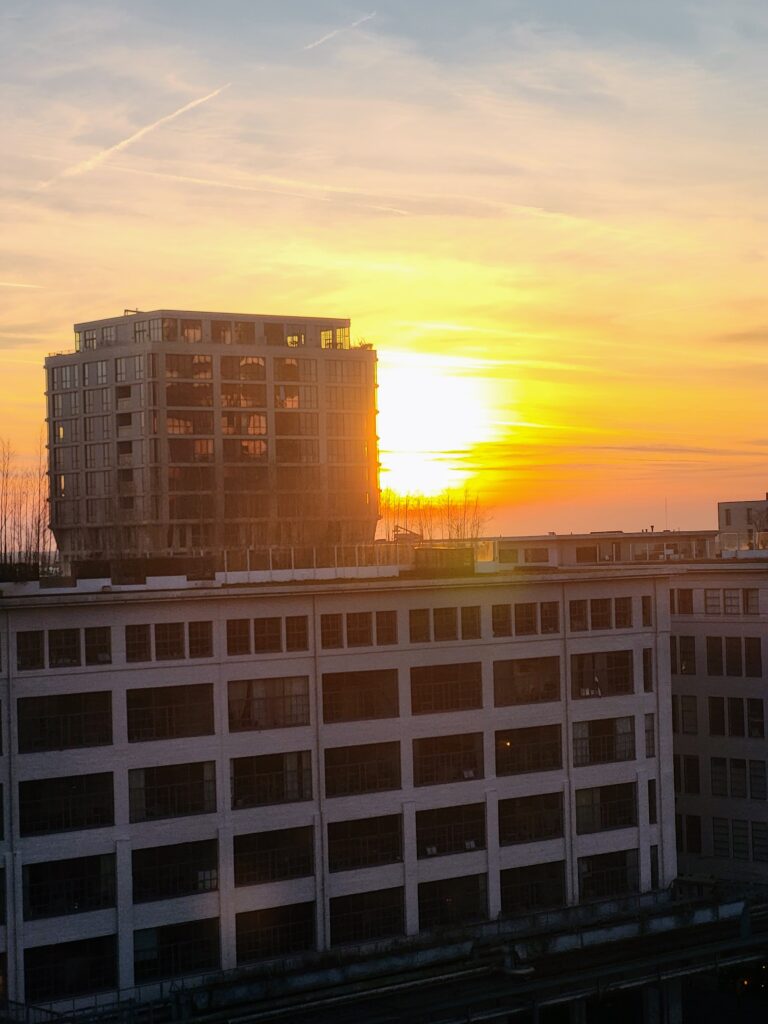Sunset over Strijp-S in Eindhoven, Netherlands, with modern apartment tower and historic industrial buildings, photo taken without filter